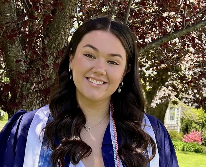 a person with long brown hair and a tree in the background